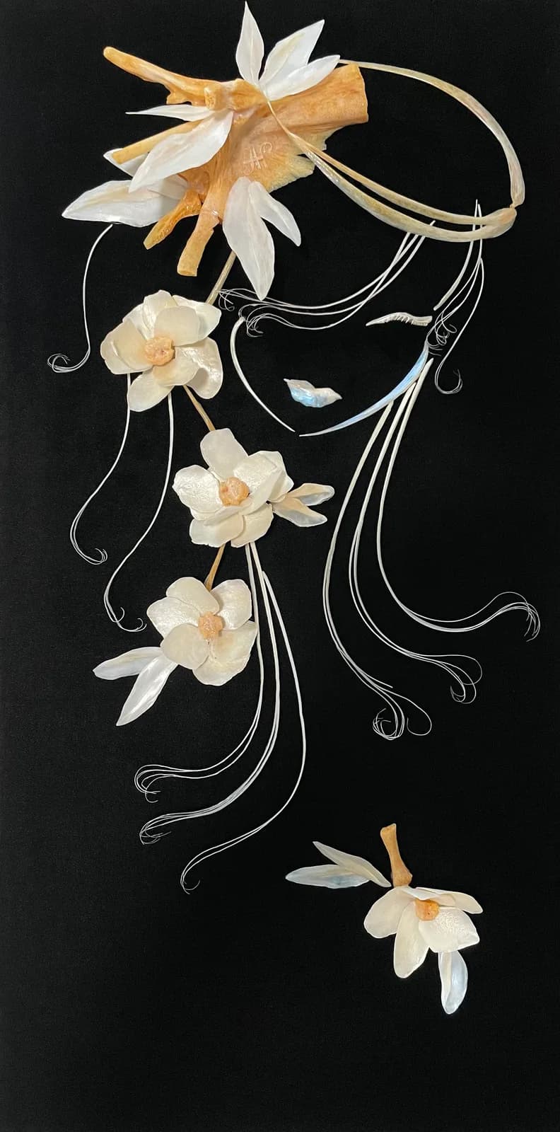 White and gold daffodils cascade from an ink-line silhouette against a black background.