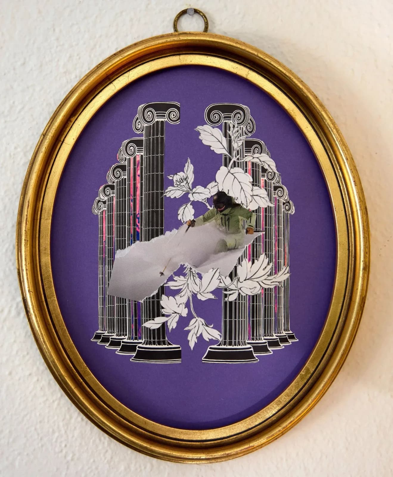 A surreal collage of classical columns, botanical elements, and a sculptural hand mounted in a gilded oval frame against a deep purple background.