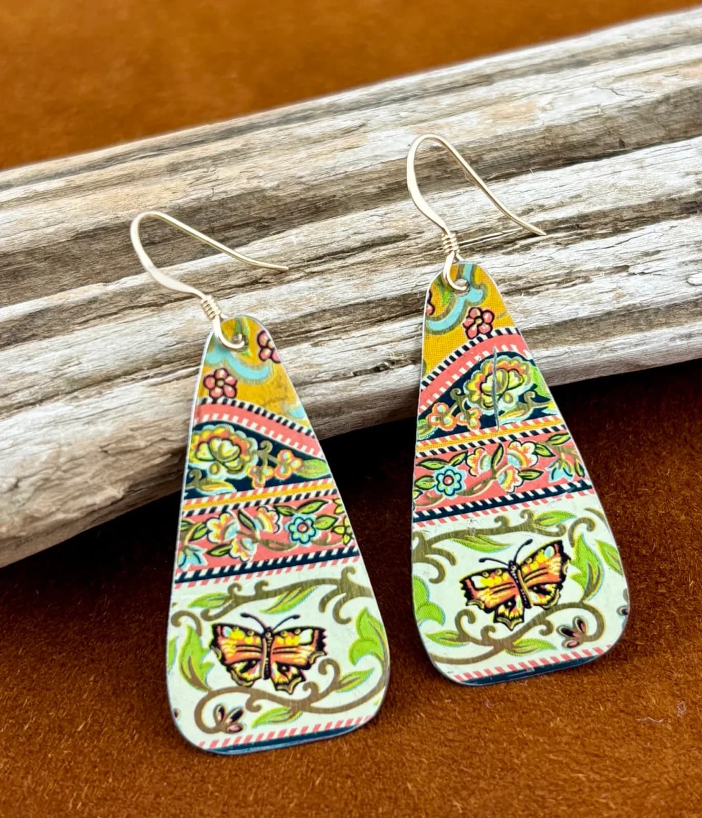 Hand-painted enamel earrings with butterfly and floral motifs in folk art style.