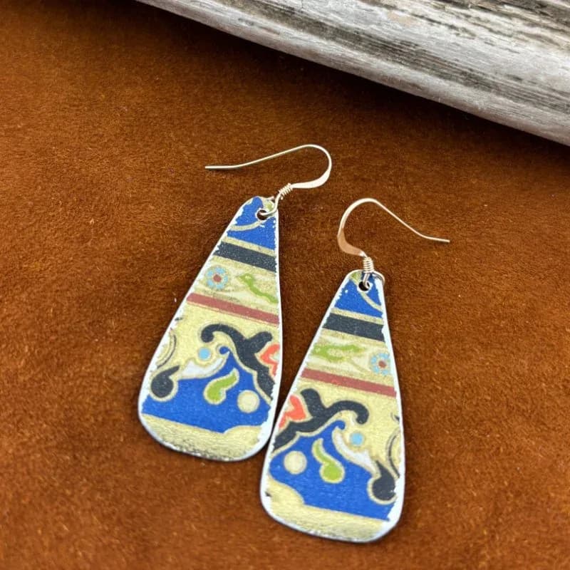 Pair of hand-enameled drop earrings featuring blue and cream geometric patterns with silver wire findings.