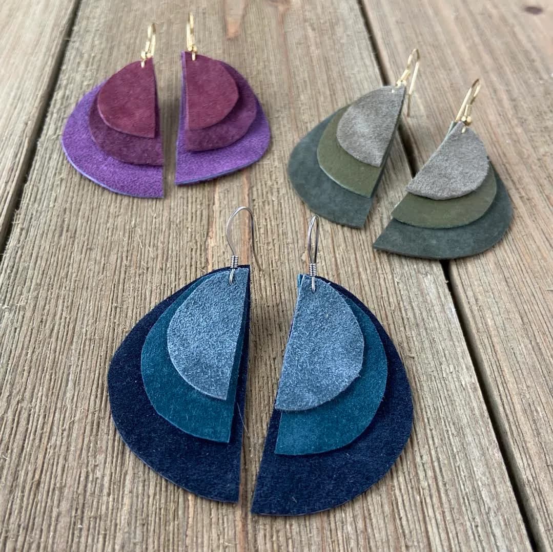 Geometric layered-felt earrings in purple, blue, and gray tones with metal ear wires.
