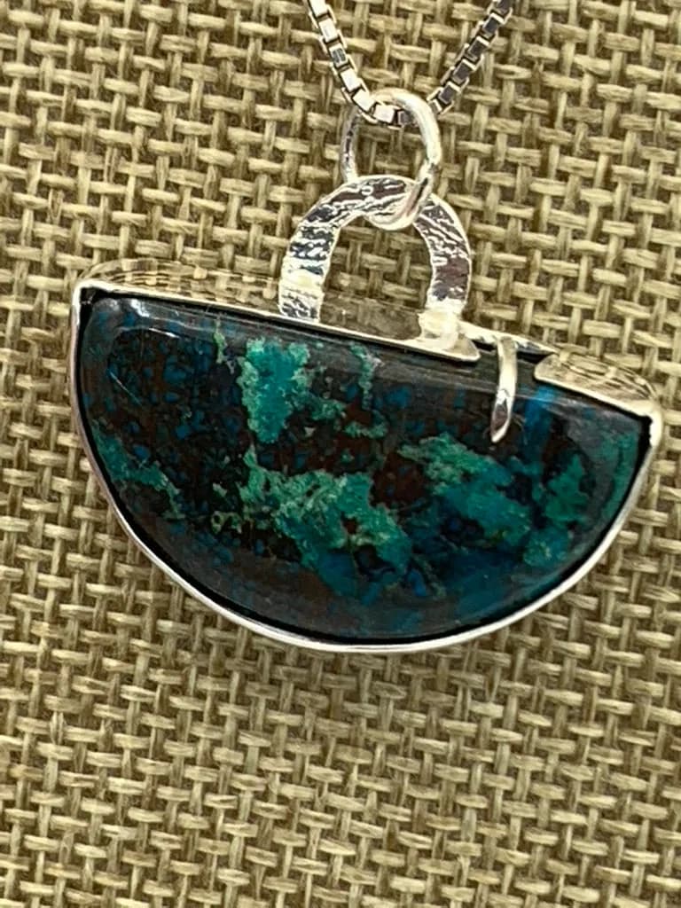 Semicircular pendant of polished azurite set in sterling silver metalwork.