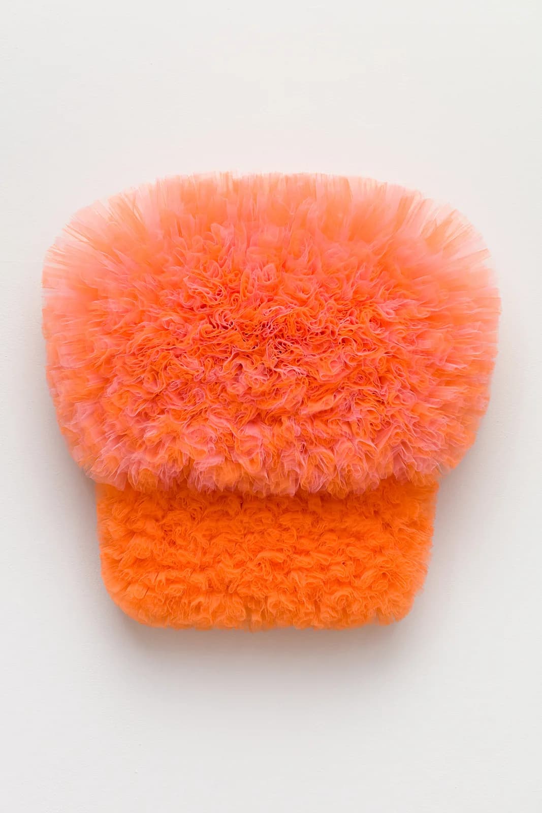 Dimensional fiber textile work in graduating orange and coral tones with layered tulle and textured surface.
