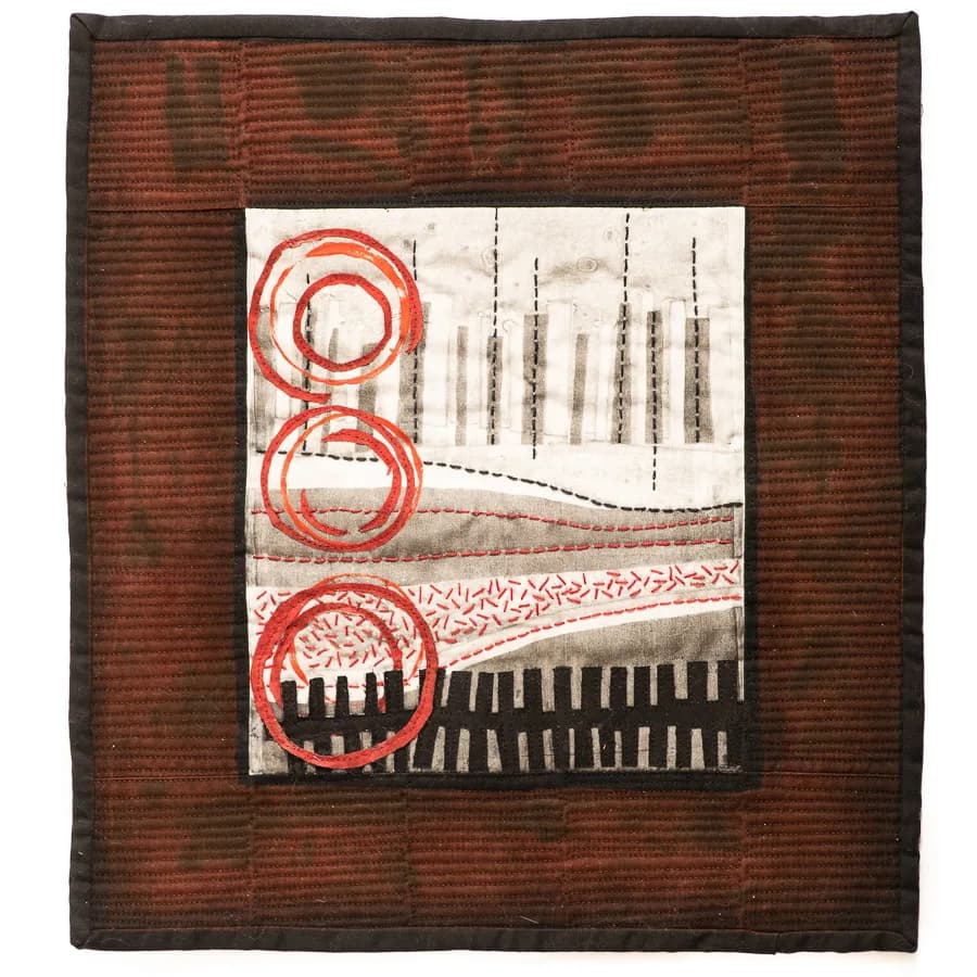 Abstract textile composition with red concentric circles, geometric patterns, and layered imagery on fabric.