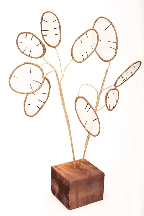 Mixed-media sculptural plant with wire-outlined leaves and wooden base, evoking botanical abstraction.