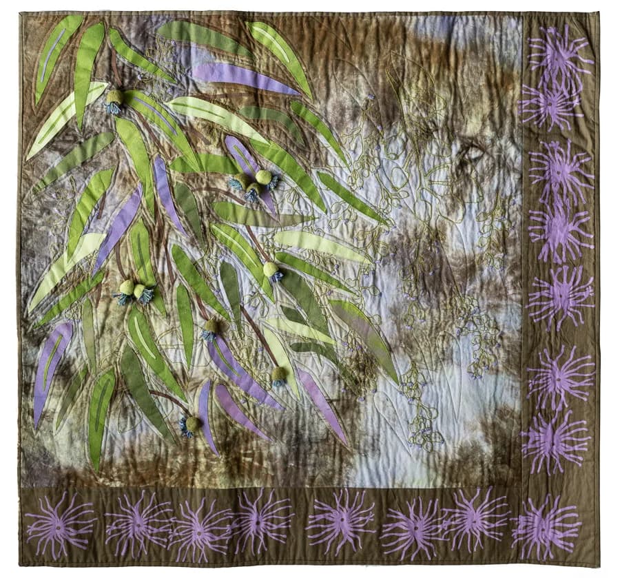 Hand-dyed and embroidered textile depicting eucalyptus leaves and purple flowering plants.