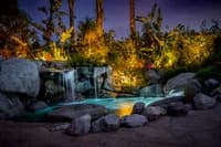 Night landscape with illuminated boulders and vegetation rendered in photography, golden and cool light.