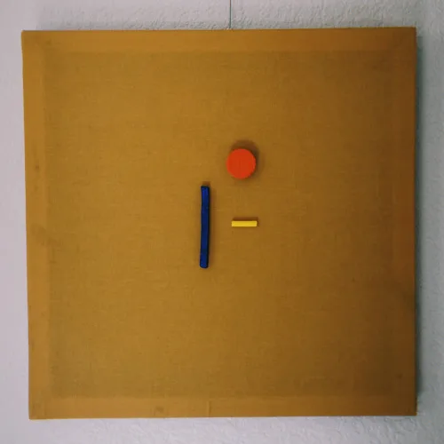 Minimalist mixed-media composition on ochre wood panel with red, blue, and yellow geometric elements.