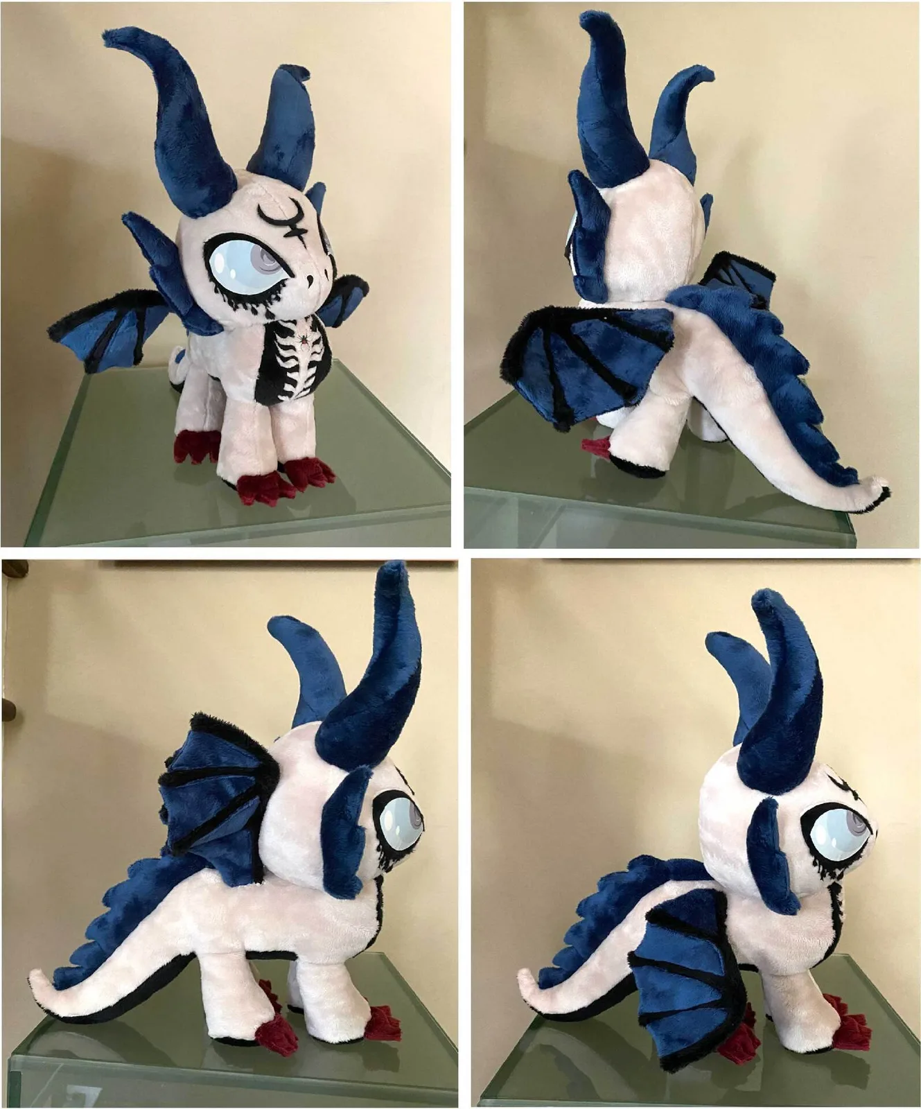 A soft-sculpture demon figure with curved blue horns, white felt body, and articulated wings shown in multiple rotations.