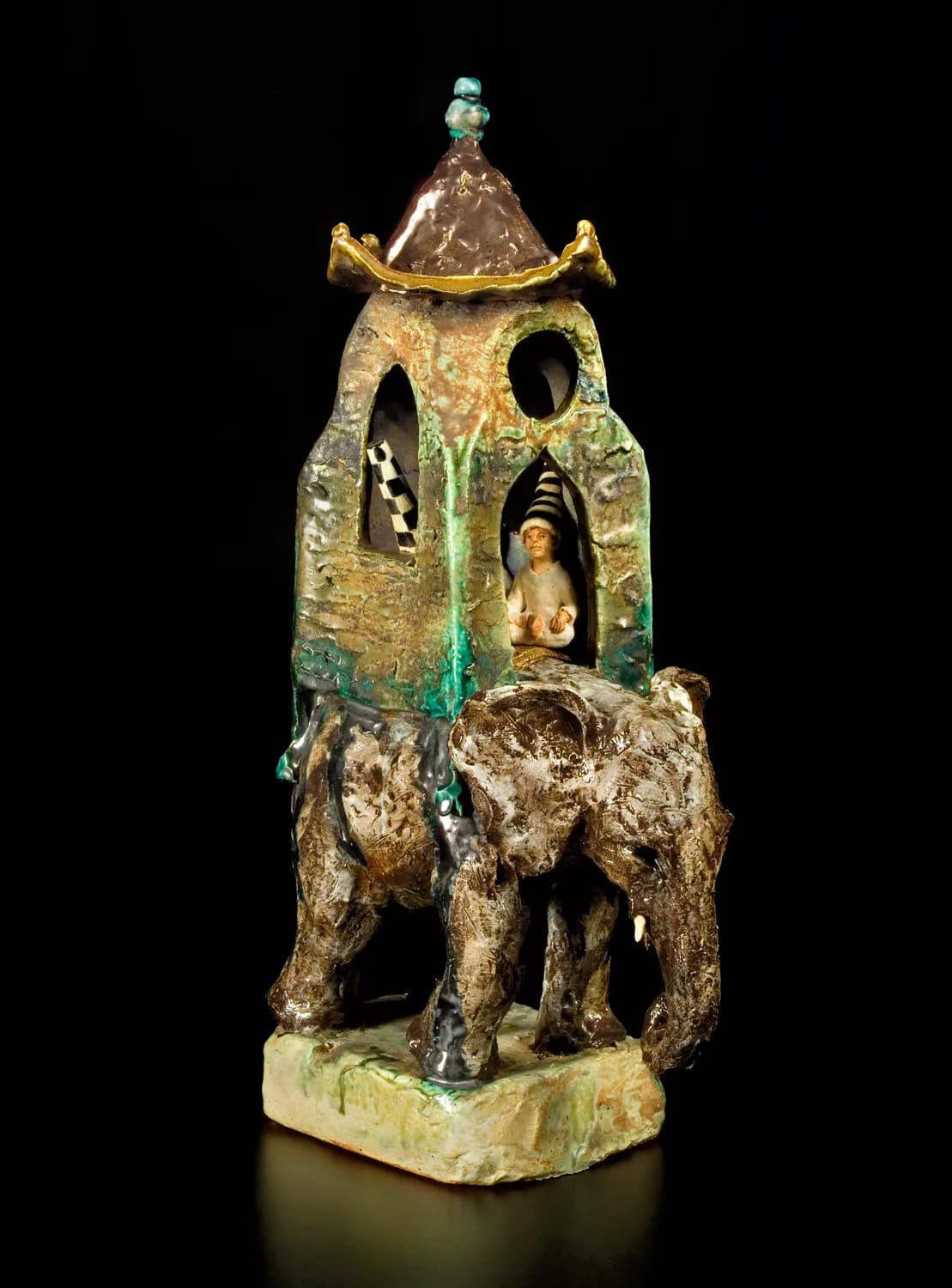 Gilt-bronze elephant sculpture with ornate tower structure, patina finish, on a raised base.