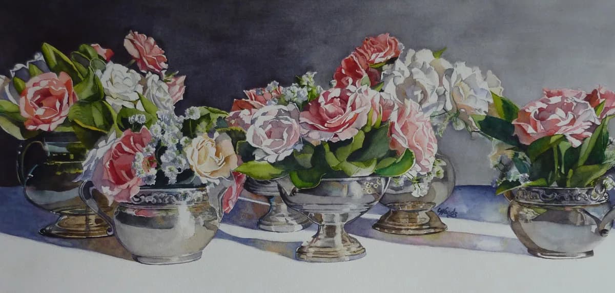 Pink, red, and white roses arranged in silver metal vessels and urns.