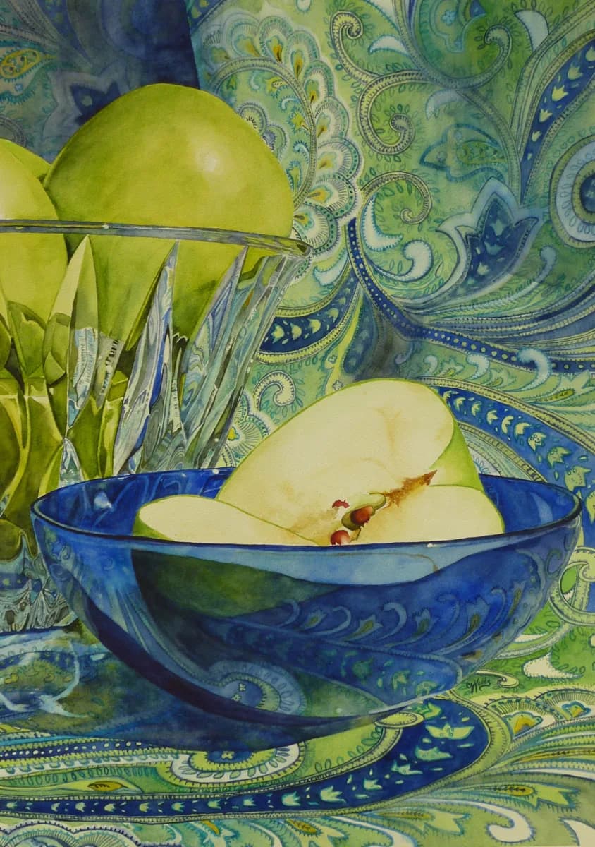 Sliced and whole apples in a blue ceramic bowl on ornamental blue-and-green fabric.