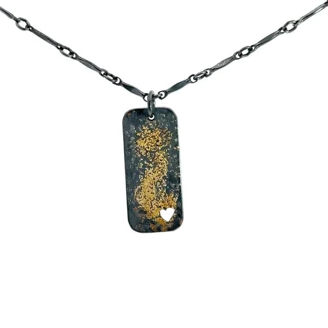 Oxidized metal pendant with gold leaf detail on adjustable chain.