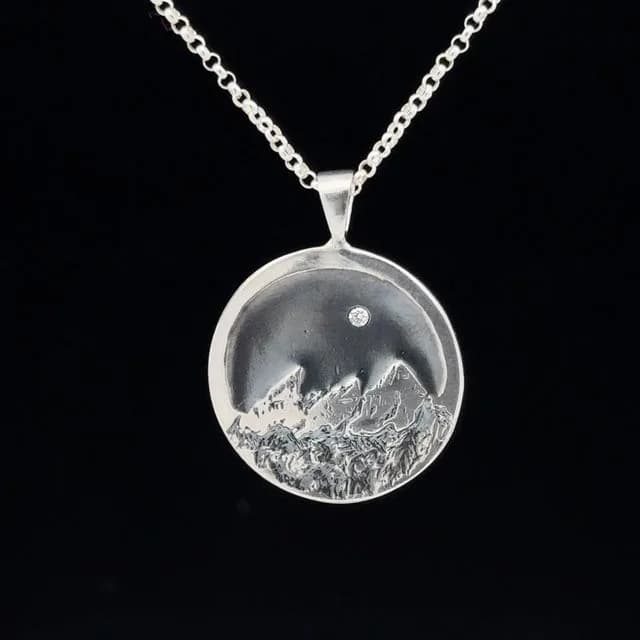 Silver pendant depicting the Boulder Flatirons beneath a night sky with moon, rendered in fine detail.