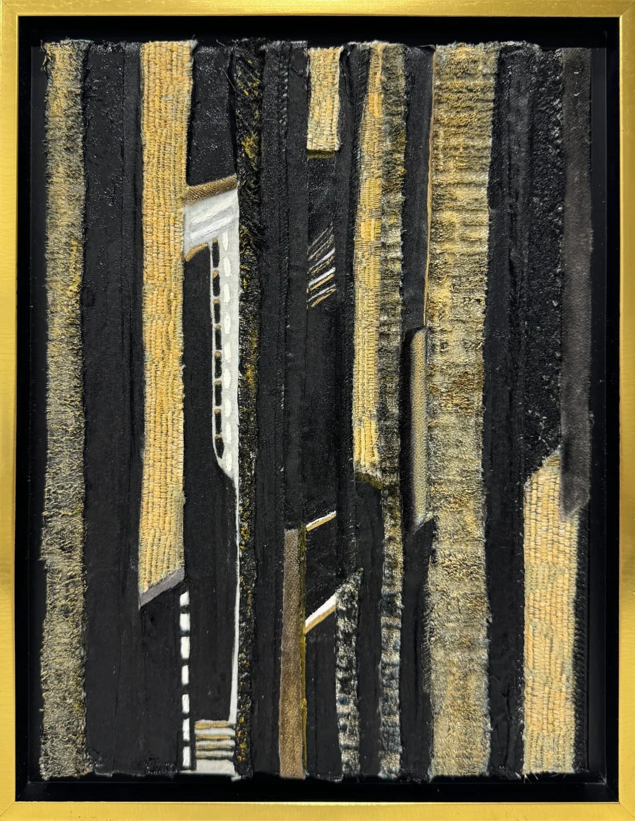 Abstract textile composition with layered vertical stripes in gold and black, combining woven and mixed materials.
