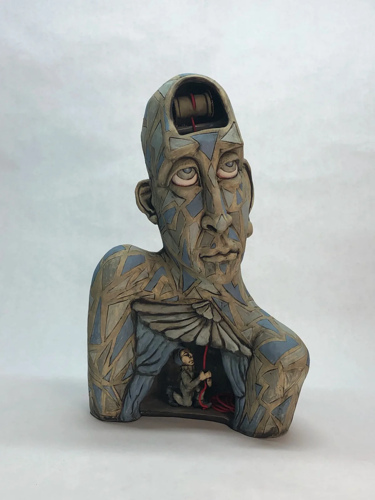 Surreal carved wooden portrait bust with an open chest cavity revealing a hidden interior figure.