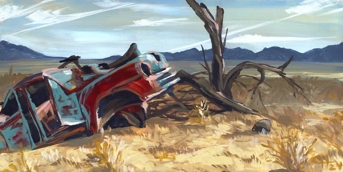 An abandoned red truck rests in an arid desert landscape with mountains and sparse vegetation.