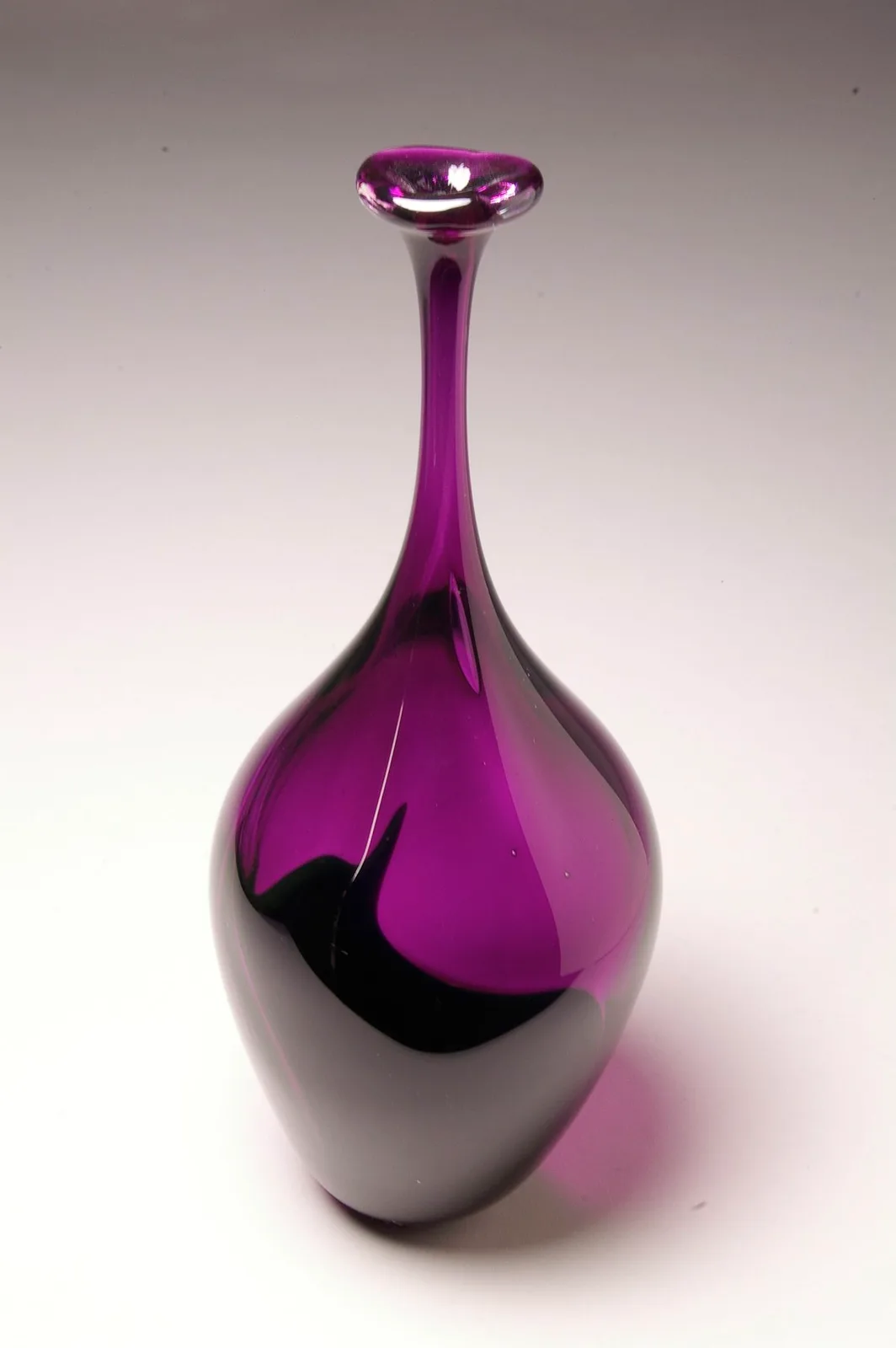 A purple and white blown glass vase with an elegant tapered form and flared rim.