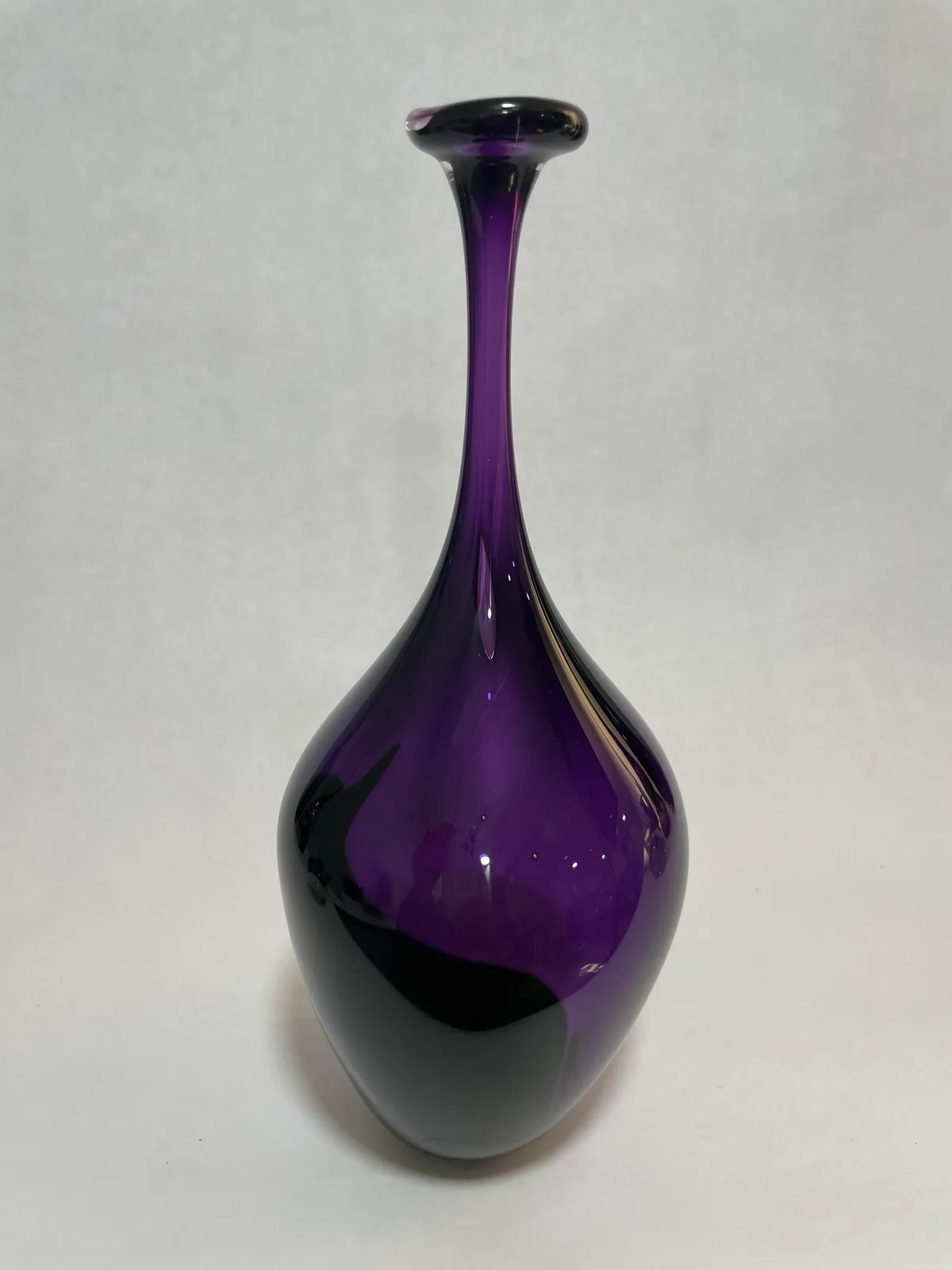 Hand-blown glass vessel in deep purple with an elegant teardrop form and tapered neck.