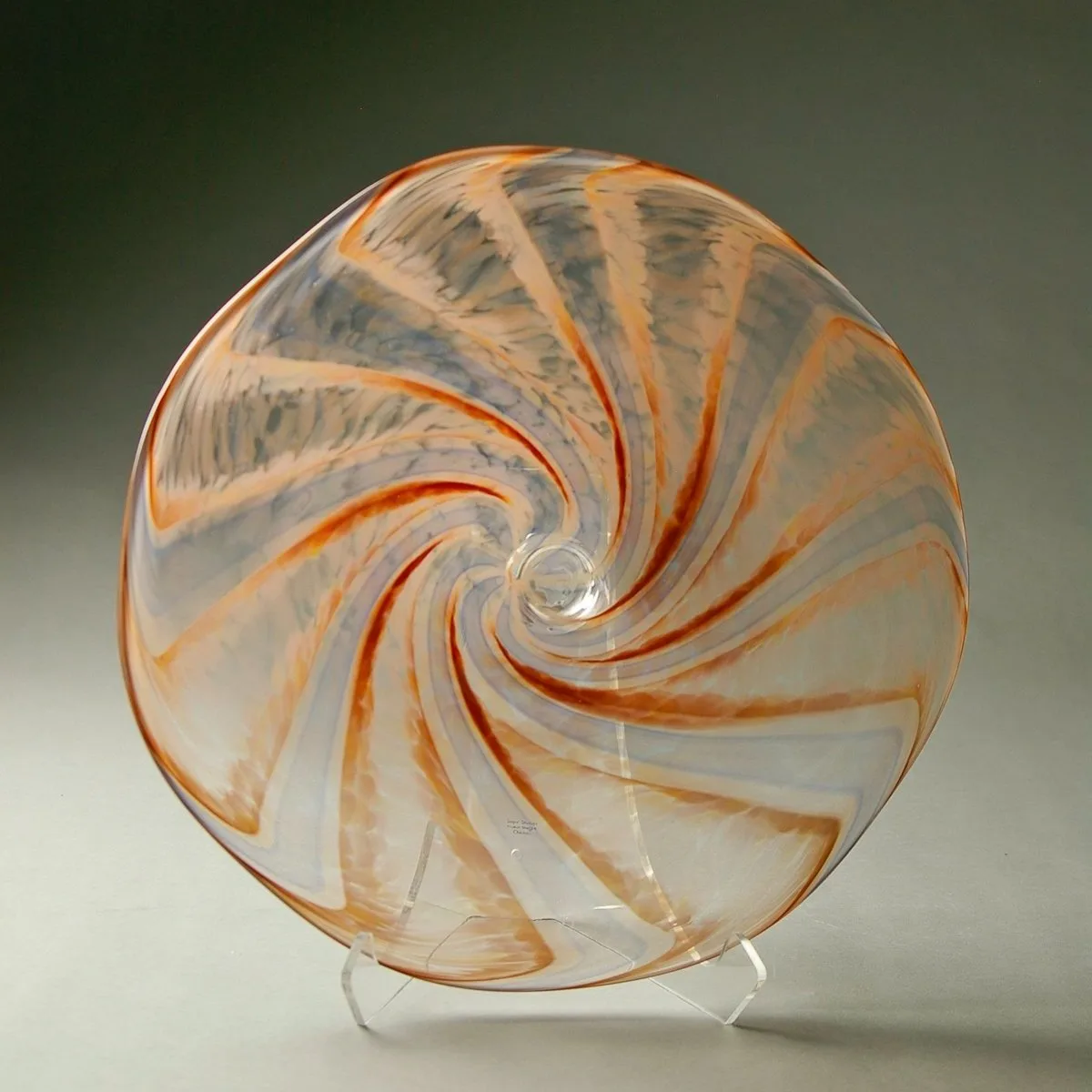 A translucent blown-glass vessel with orange and gray spiraling bands in a non-representational design.