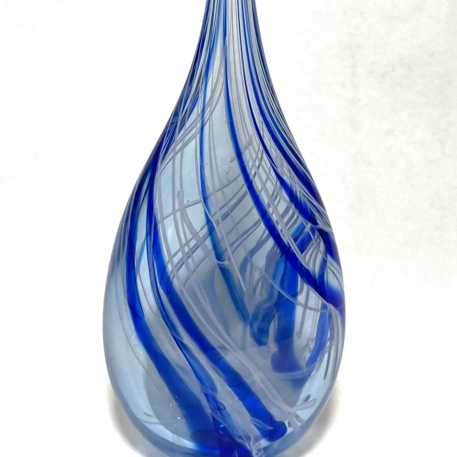 Teardrop-shaped blown glass vessel with blue spiral striations and translucent form.