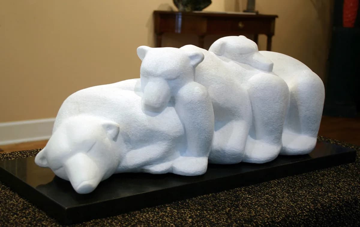 Abstract white stone sculpture of stylized polar bears in a family group composition.