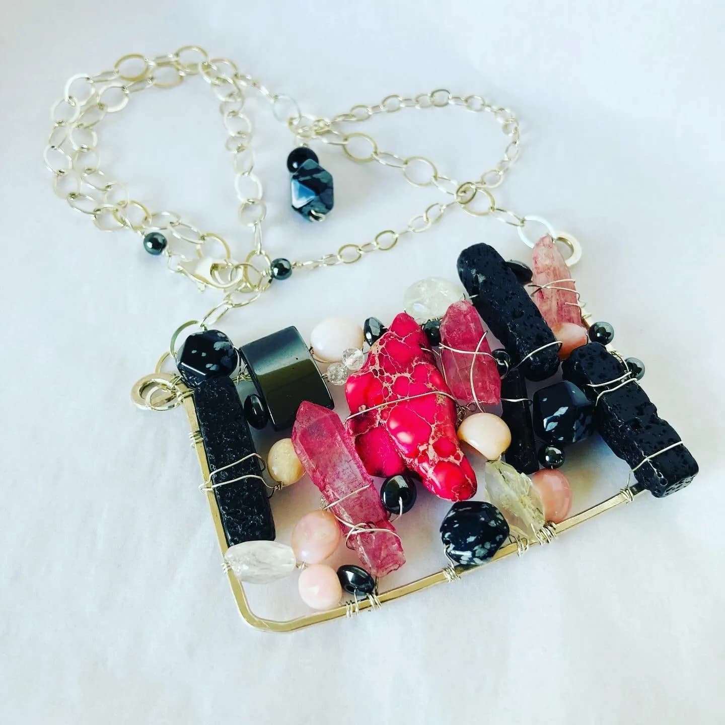 Wire-wrapped pendant necklace with tourmaline, pearls, and gemstone beads on silver chain.
