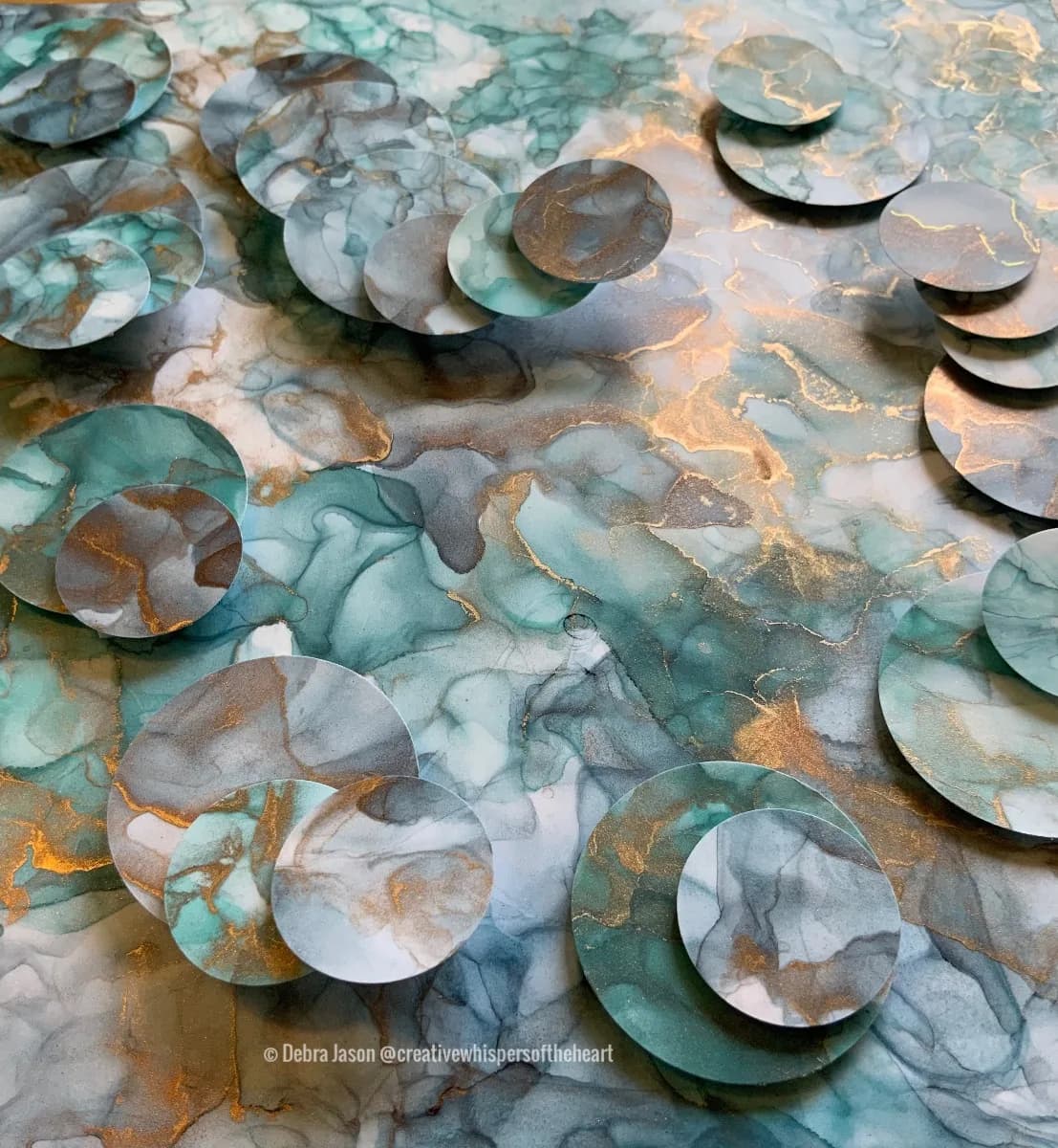 Layered translucent paper circles with watercolor in teal, cream, and gold create dimensional abstract composition.