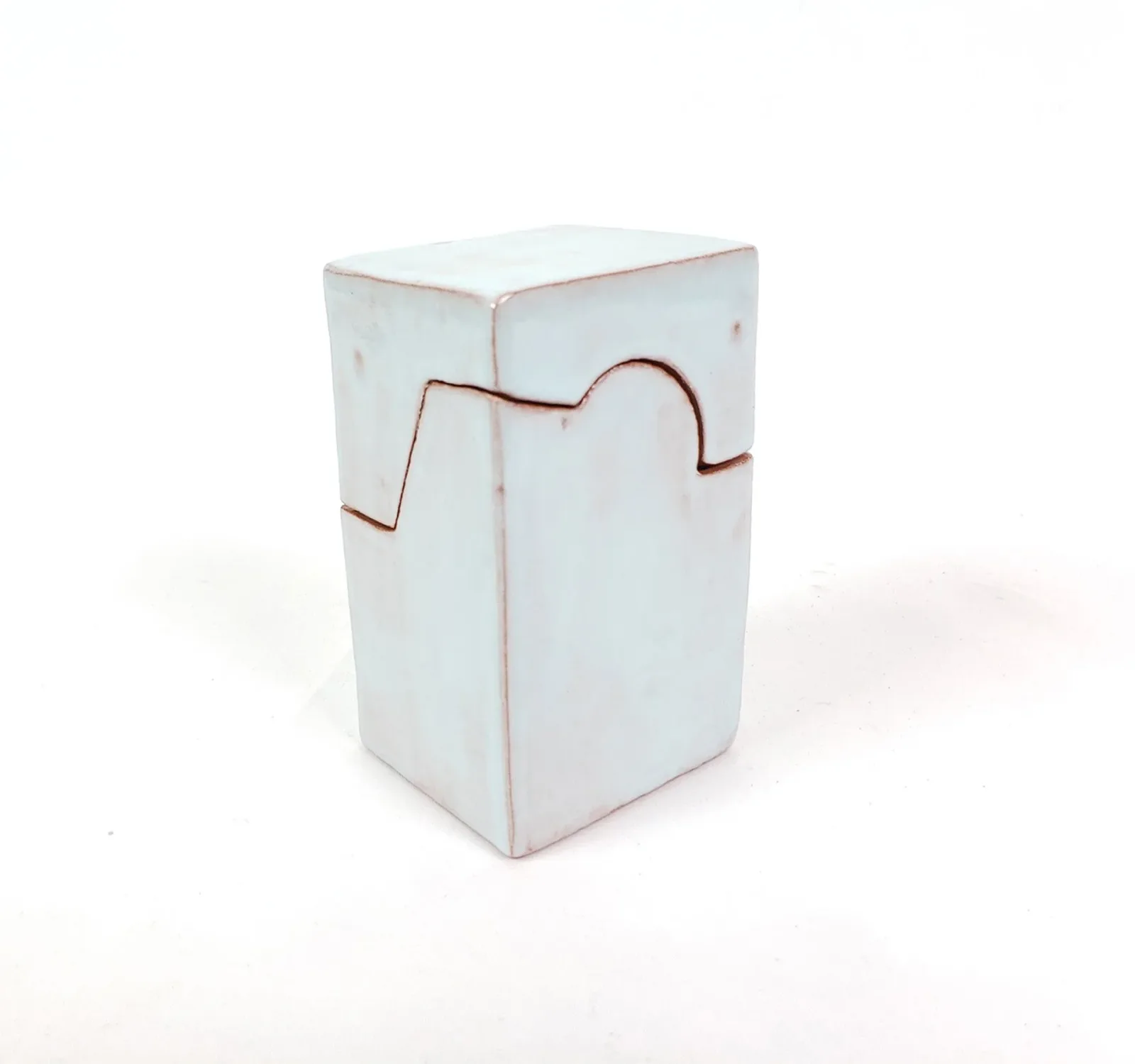 White ceramic form with rust-colored linear incisions creating a geometric abstract composition.