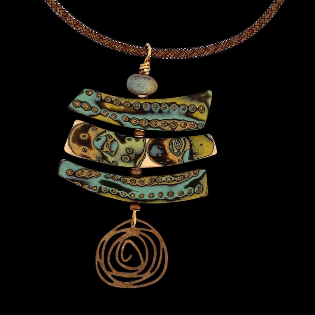 Multi-tiered copper and enamel pendant with turquoise inlay suspended from a braided copper chain.