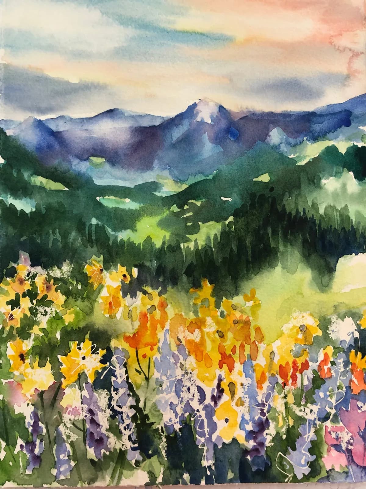 A watercolor landscape depicting a wildflower meadow beneath the Boulder Flatirons and misty peaks.