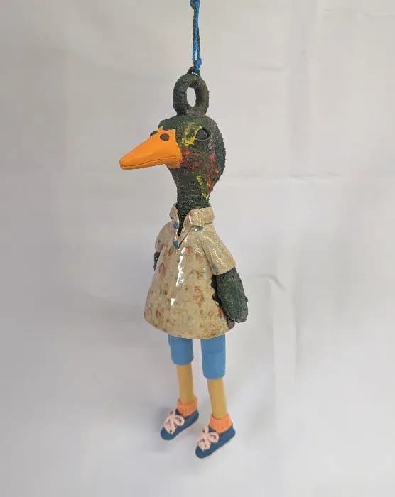 Handmade ceramic duck ornament with textured plumage, painted details, and articulated legs.