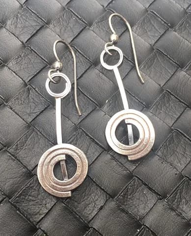Pair of mixed-metal earrings with circular geometric forms, handcrafted in silver and copper.