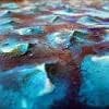 Non-representational mosaic artwork composed of turquoise, blue, and burgundy glass tiles.