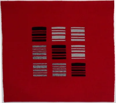 A red textile composition with a grid of black and gray horizontal striped rectangles arranged in nine sections.