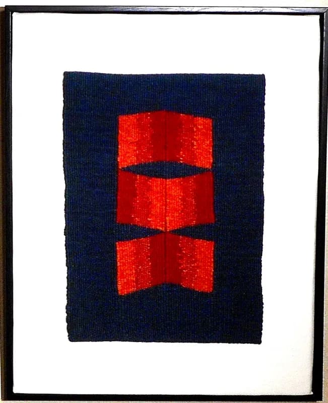Three stacked red rectangles on a dark navy fiber panel, textile artwork.