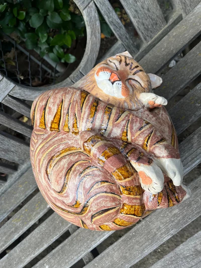 Hand-carved and painted wooden tiger sculpture with striped detailing and expressive face.
