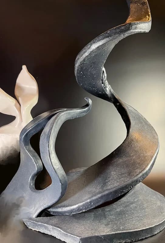Abstract bronze sculpture with flowing, curved organic forms and patinated surface.