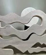 Abstract ceramic sculpture with undulating white form and organic curved contours.