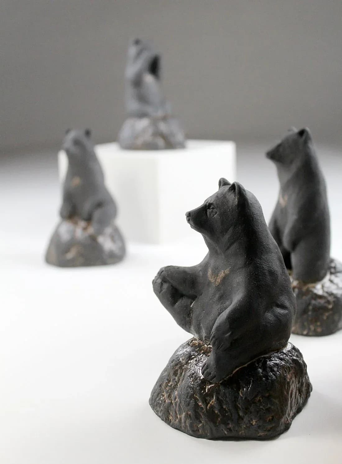 Bronze cast squirrel sculptures, seated on textured stone bases, arranged as an installed set.
