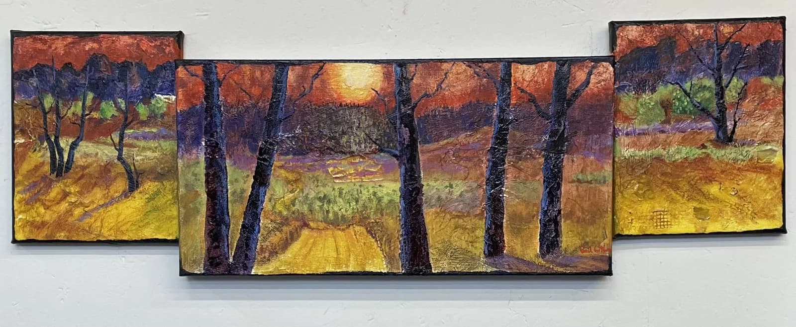 A triptych oil painting depicts an autumn landscape with dark trees framing a golden field beneath a warm sky.