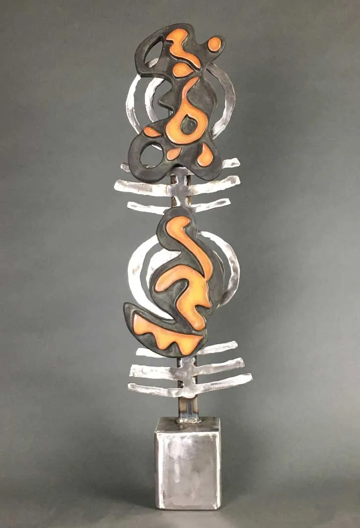 Vertical metal sculpture with stacked abstract forms in steel and copper or bronze, mounted on a cubic base.