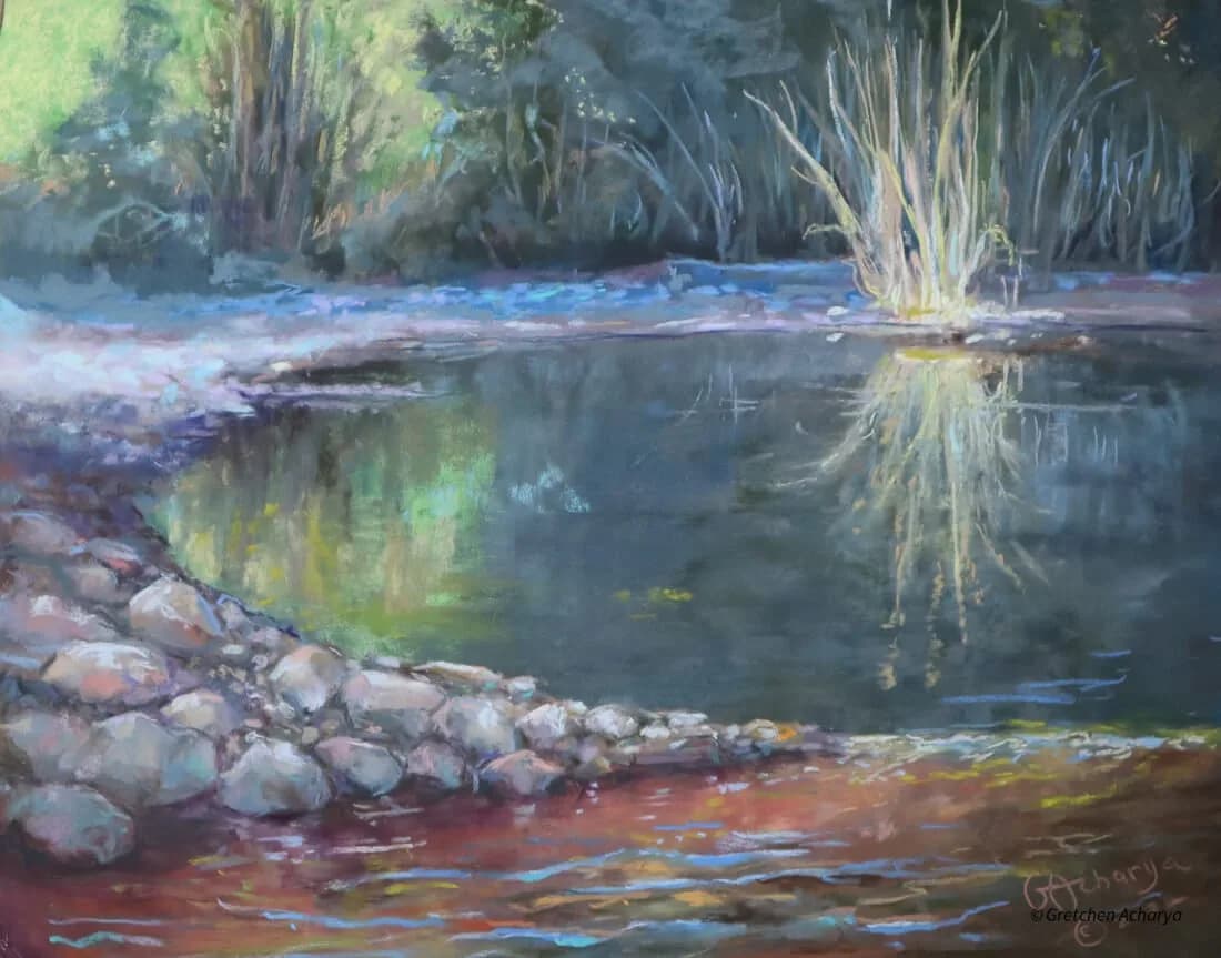 A riverside landscape with willow trees reflected in calm water over colorful rocks, rendered in soft pastel.