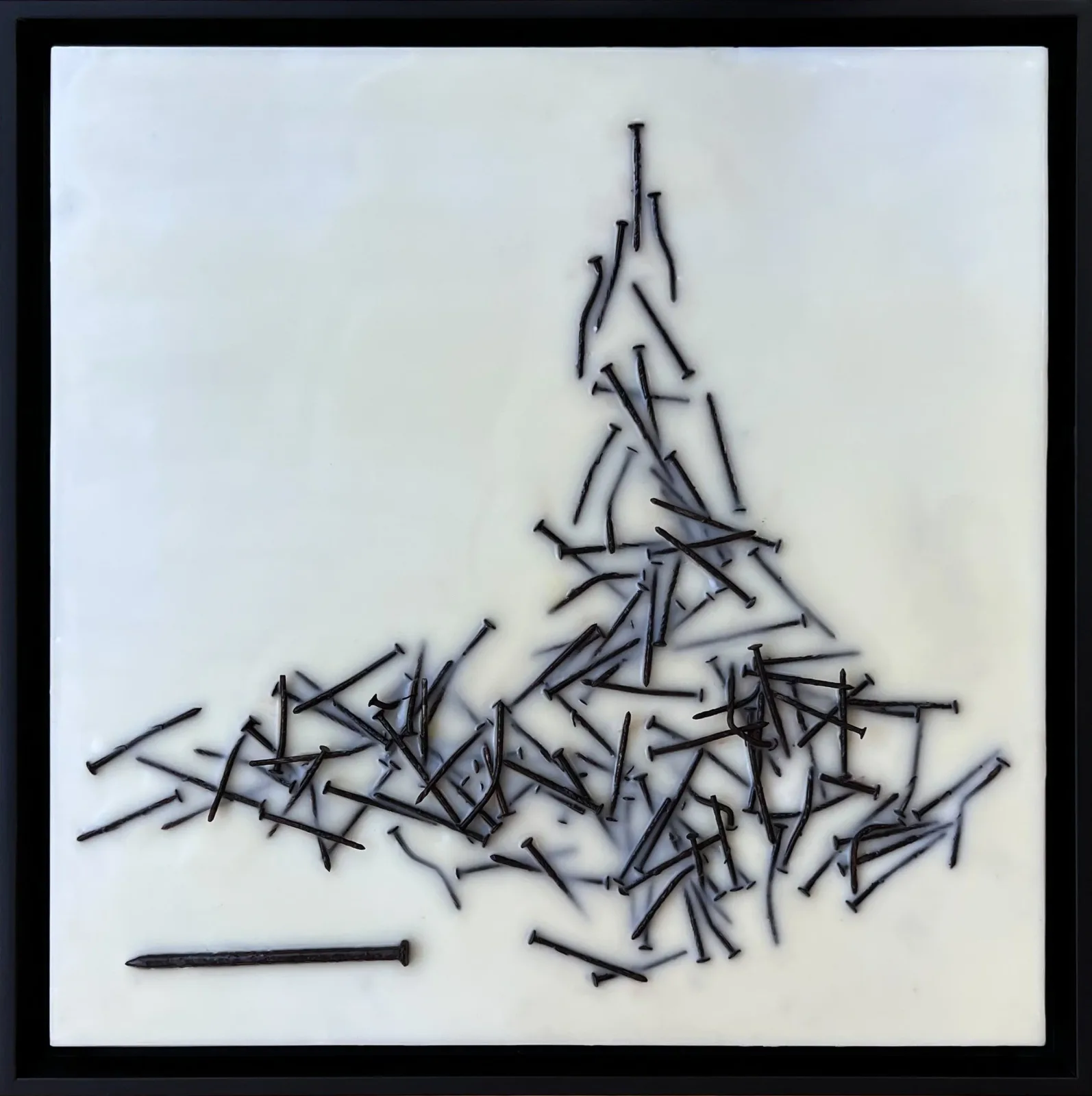 Abstract triangular composition constructed from nails arranged on white paper, executed in iron and silver tones.