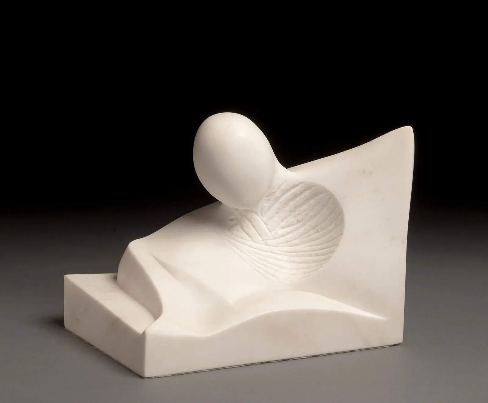 Abstract white stone sculpture with organic, biomorphic forms on a neutral background.