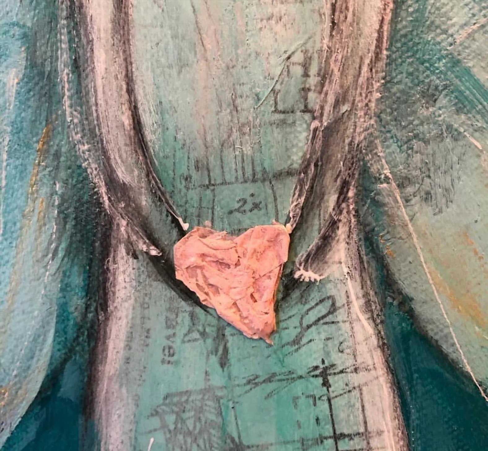 A pink clay heart rests on weathered green and mauve wooden boards in this oil painting.