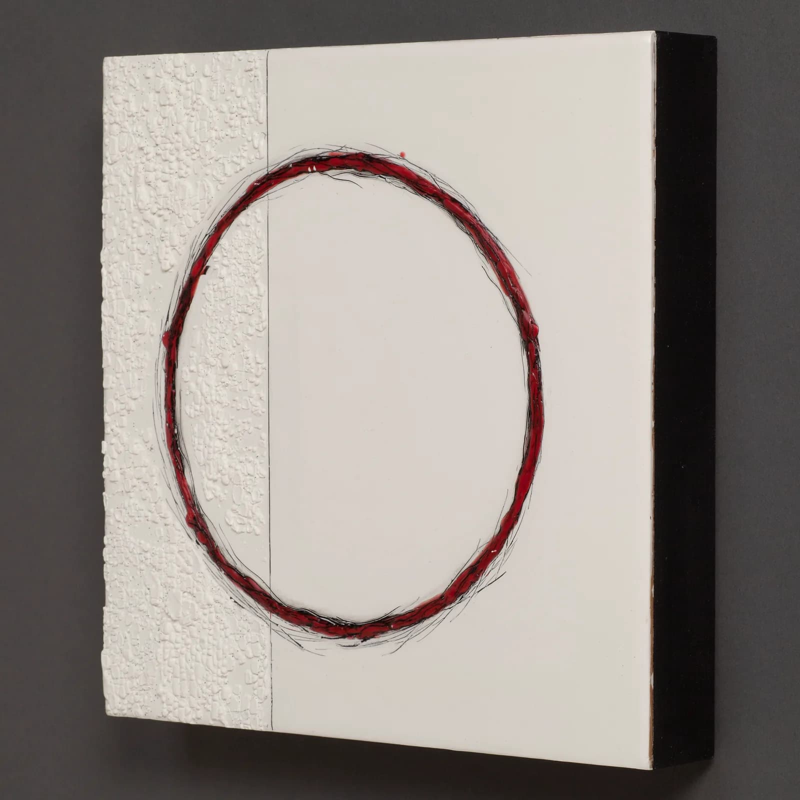 A red brushed circle drawn on textured cream and black paper, creating a non-representational composition with dimensional layering.
