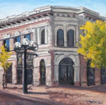 Watercolor or oil painting of a historic brick building with arched windows, street lamp, and sycamore trees.