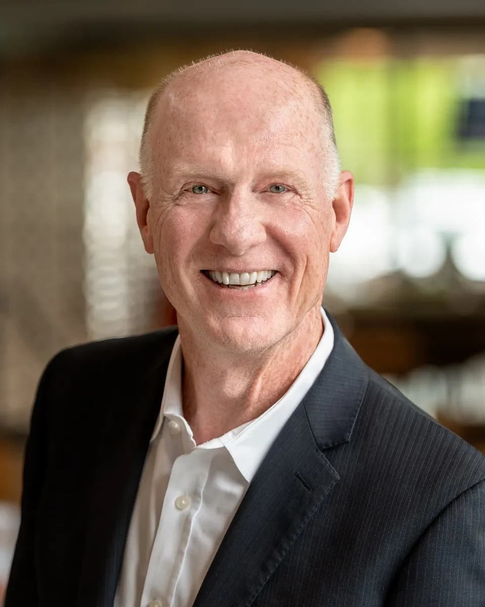 Posed portrait photograph of a man in business attire.